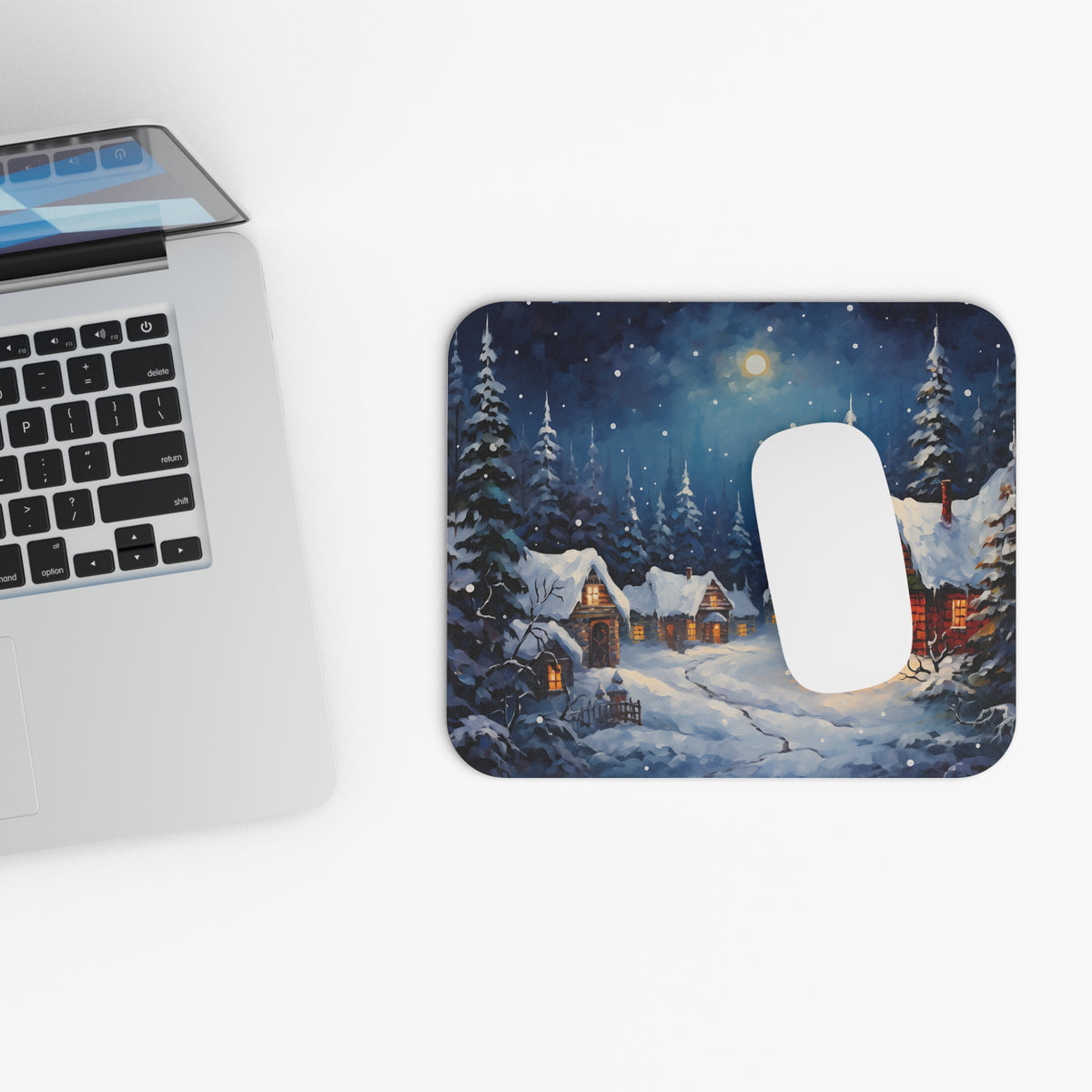 Mousepad with painted winter village scene and snow-covered evergreen trees.