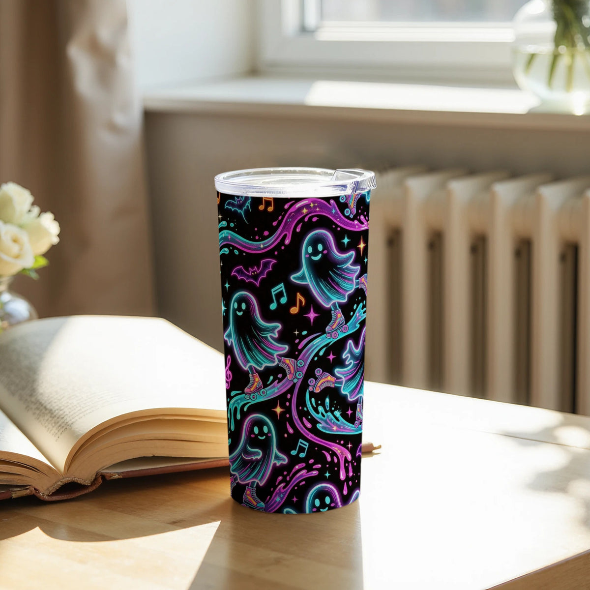 Black tumbler with colorful ghosts, bats, and musical notes on roller skates.