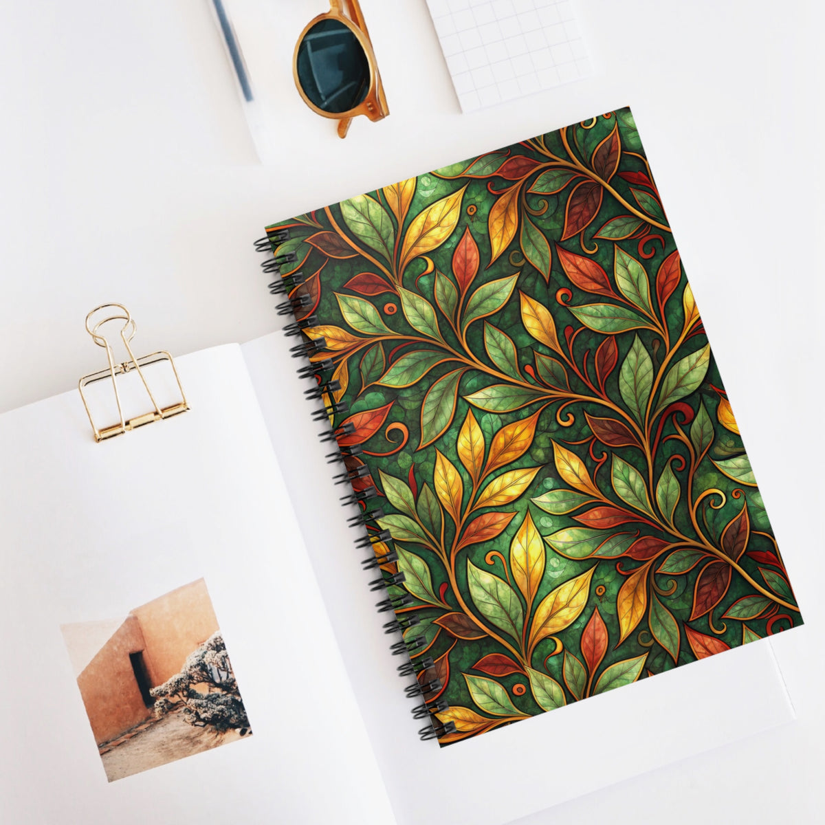 Spiral-bound notebook with a green and gold art nouveau leaf pattern.