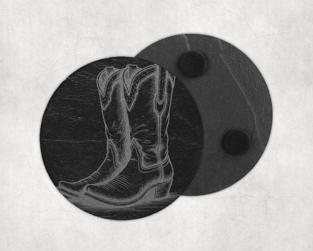 Engraved cowboy boot design on a round, dark slate coaster with two felt pads.