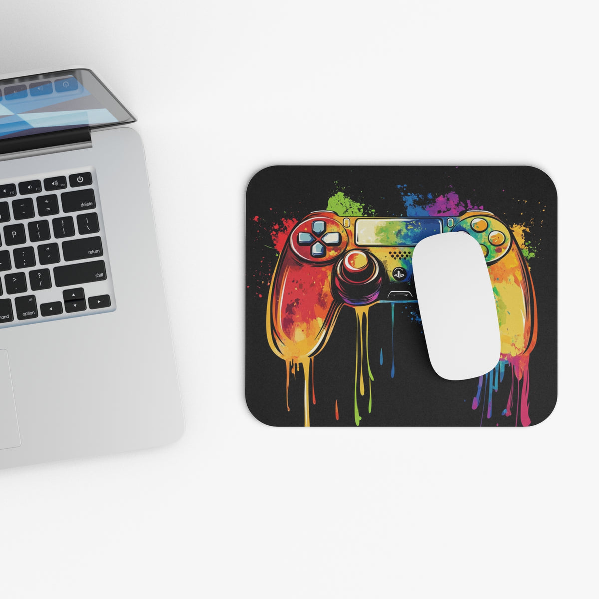 Mousepad with colorful paint splatter video game controller design and white mouse.