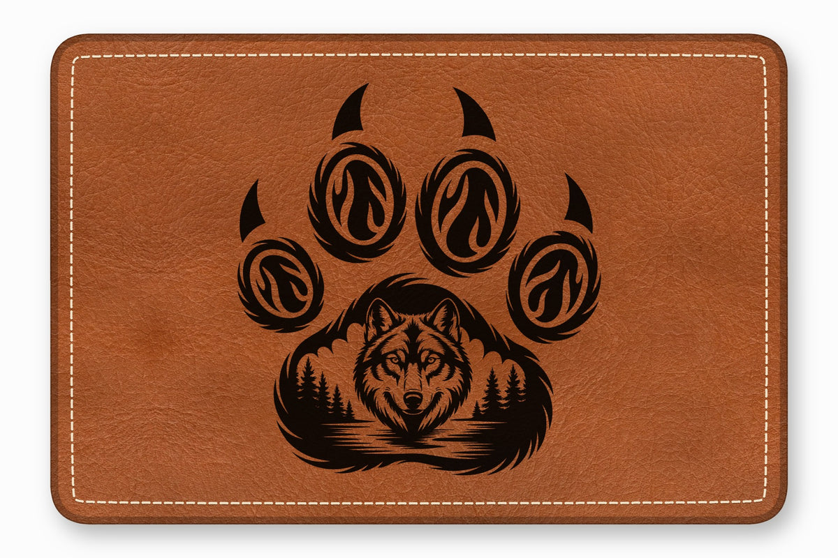 Brown rectangular leather patch with white border stitching and a black engraved wolf in a forest paw print graphic.