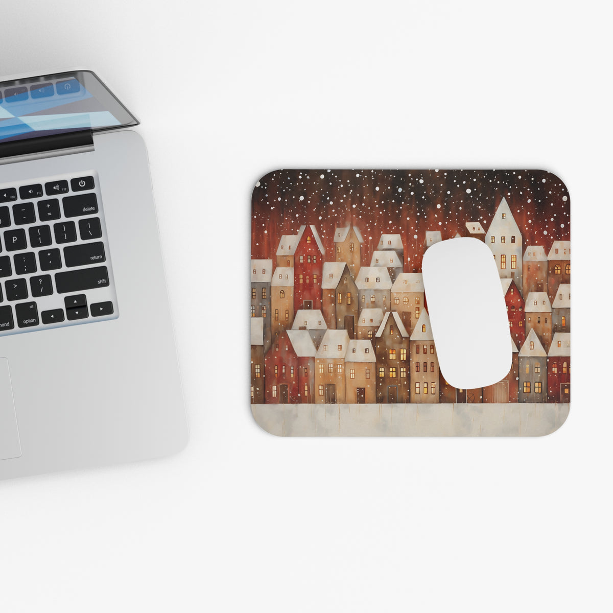 Mousepad with painted houses and falling snow under a dark sky.