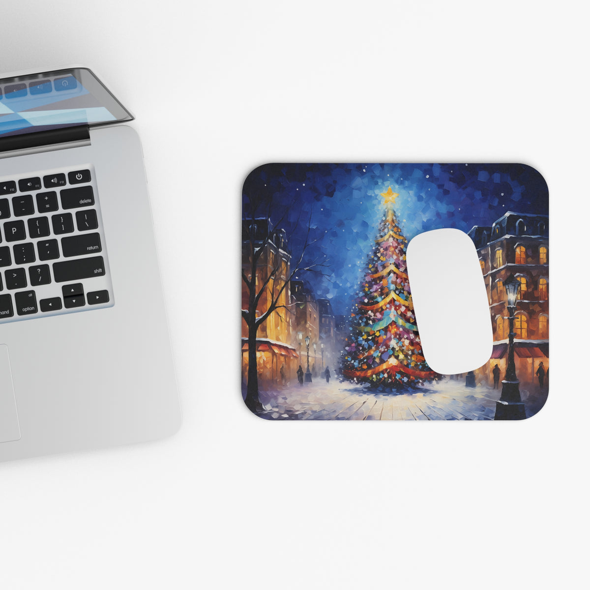 Mousepad with a painted Christmas scene of a decorated tree and snowy street.