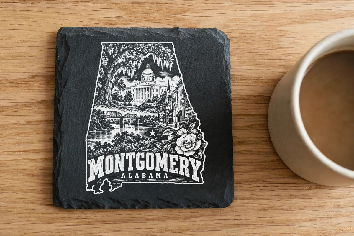 A square slate coaster with a white engraved map of Alabama containing Montgomery landmarks and text.