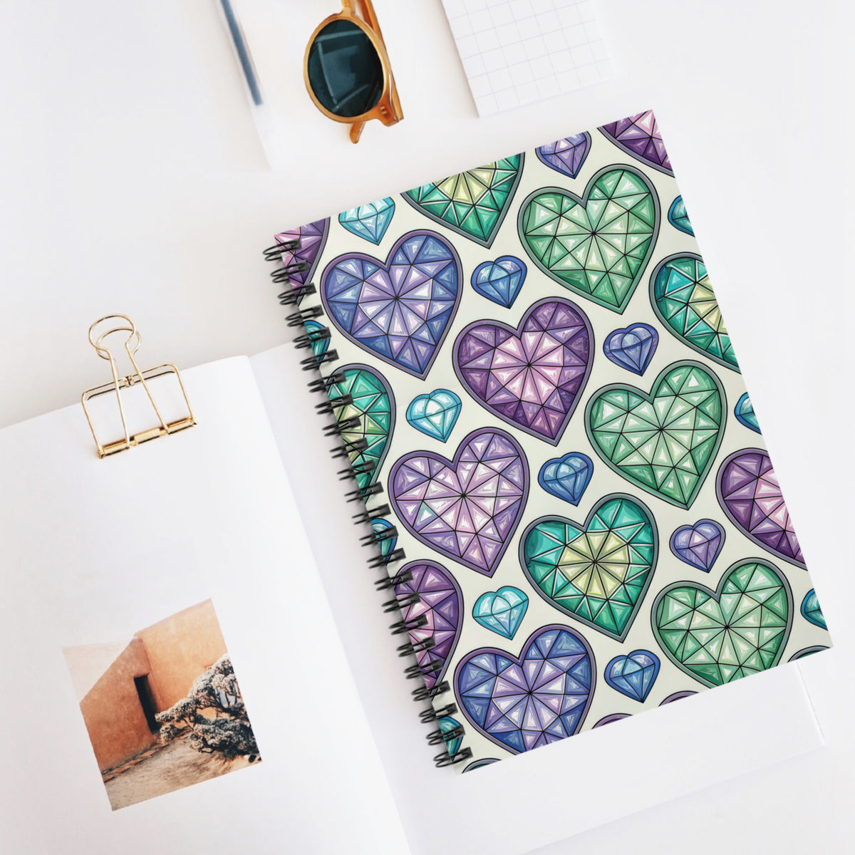 Notebook with a pattern of colorful stained-glass heart shapes and diamond shapes.
