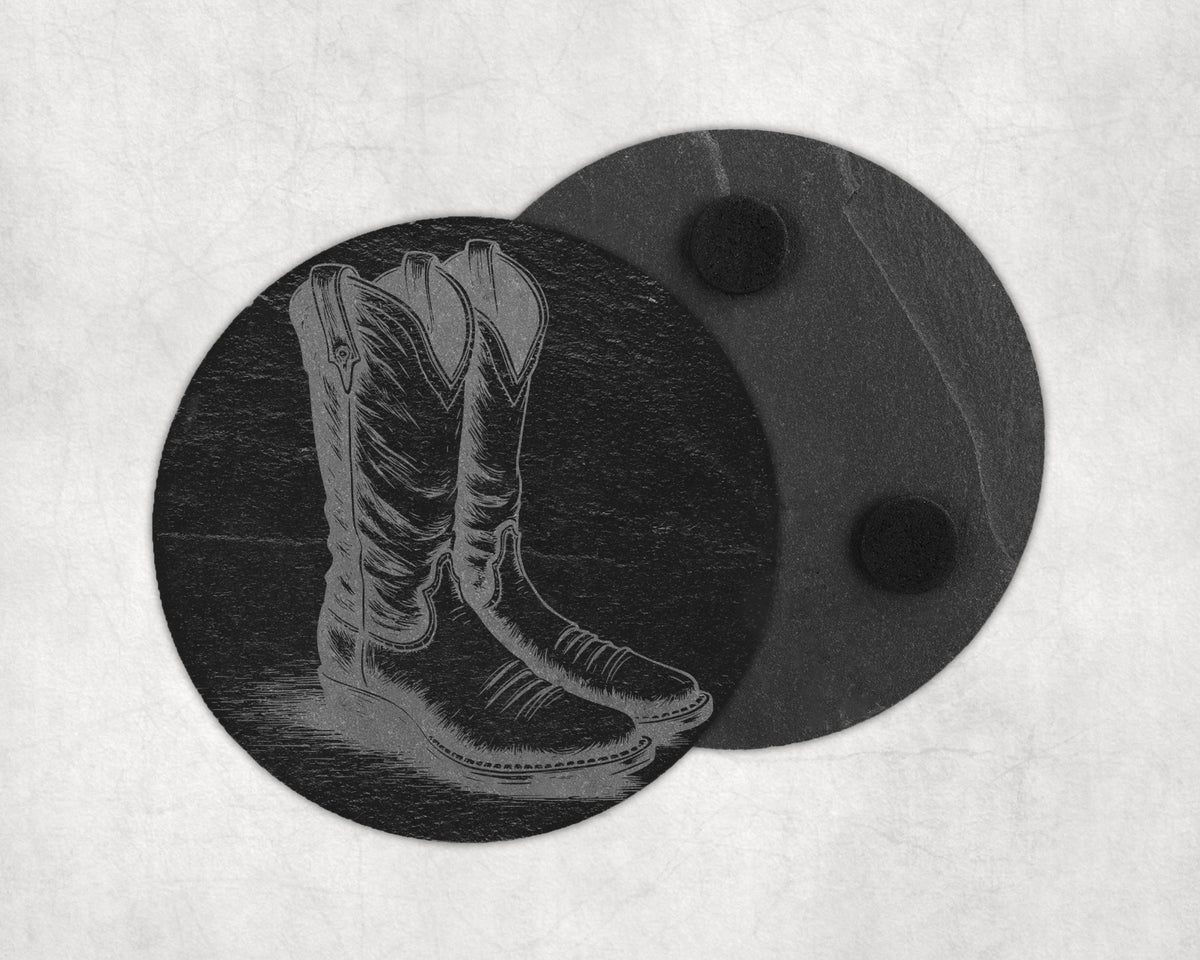 Engraved cowboy boots design on a round slate coaster with two black felt feet.