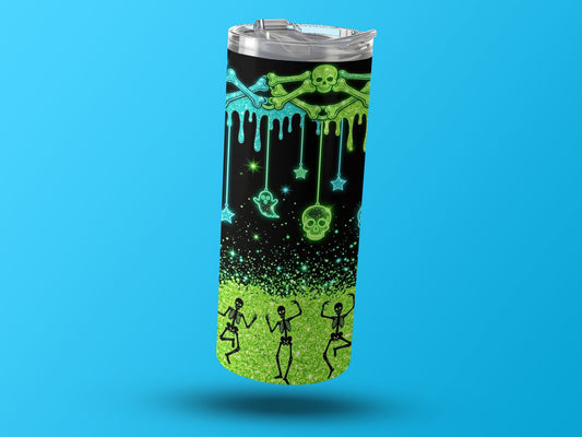 Tumbler with dripping skulls, bones, ghosts, stars, and dancing skeletons on black and green glitter background.