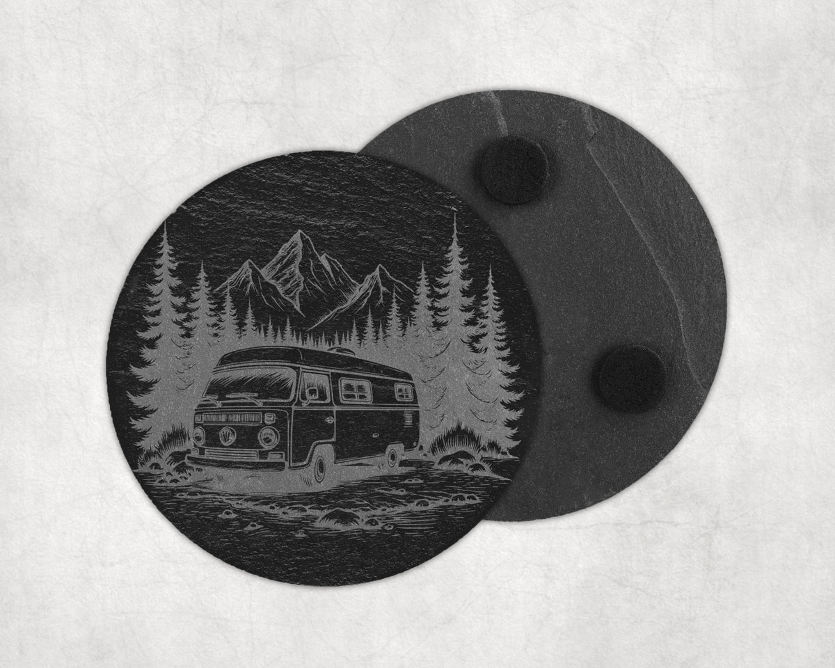 Round slate coaster etched with a vintage camper van, pine trees, and mountains.