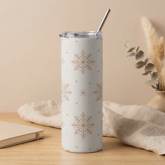 White tumbler with a repeating gold snowflake pattern and a silver straw.