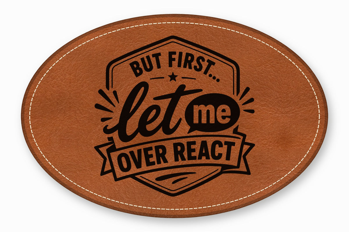 An oval brown leather patch with white stitched borders and black text reading But First let me OVER REACT.