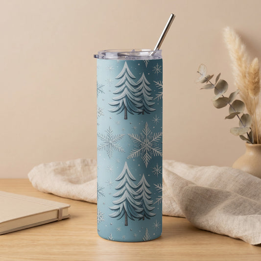 Blue tumbler with white Christmas trees and snowflakes, featuring a metal straw.