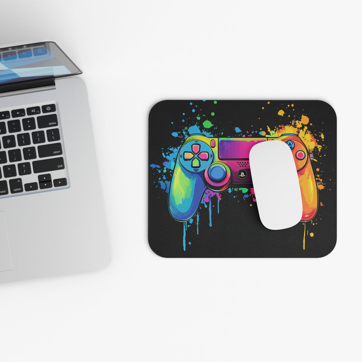 Colorful gaming controller art with paint splatters on a black mousepad.