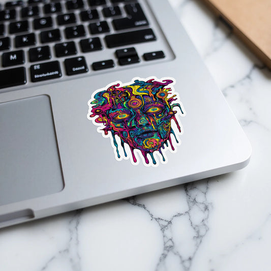 Colorful abstract face sticker with dripping details on a laptop.