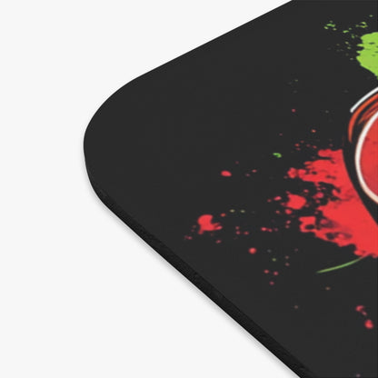 Black mousepad with red and green paint splatters and a partial red circular design.