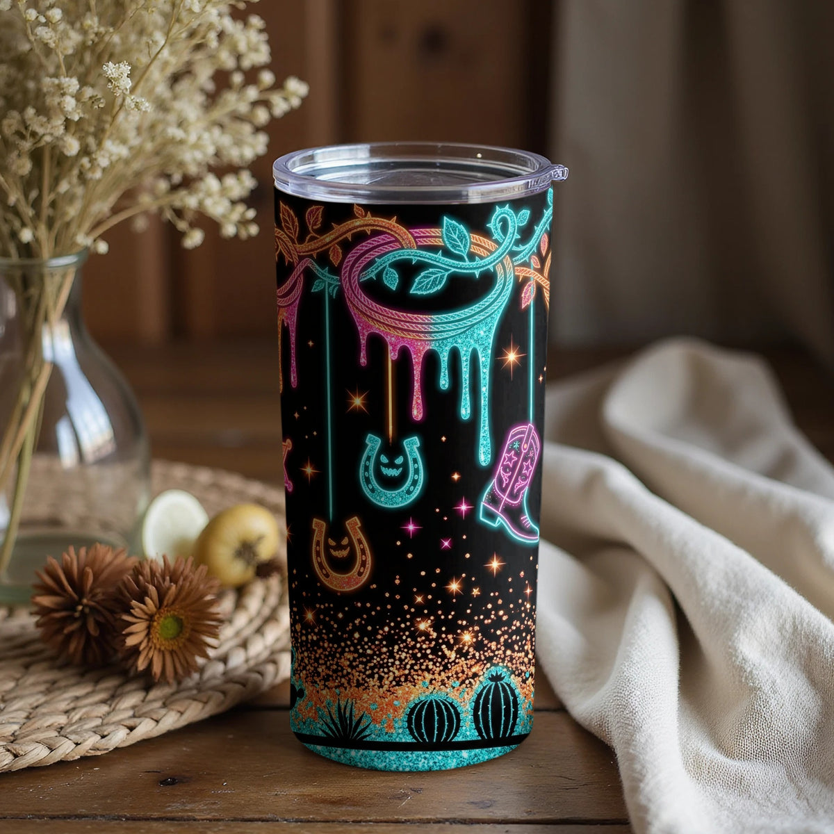 Black tumbler with neon cactus, horseshoe, and cowboy boot pattern.
