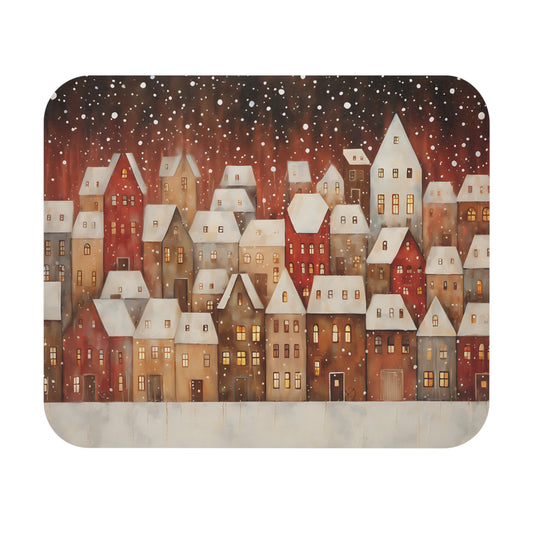Winter village scene with snow falling on cozy, lit houses.