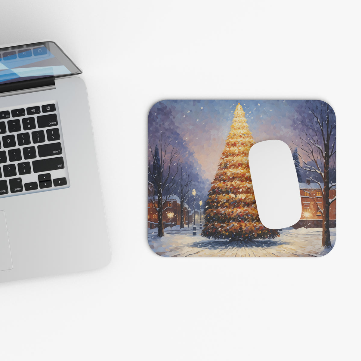 Mousepad with a snowy village scene and a lit Christmas tree.