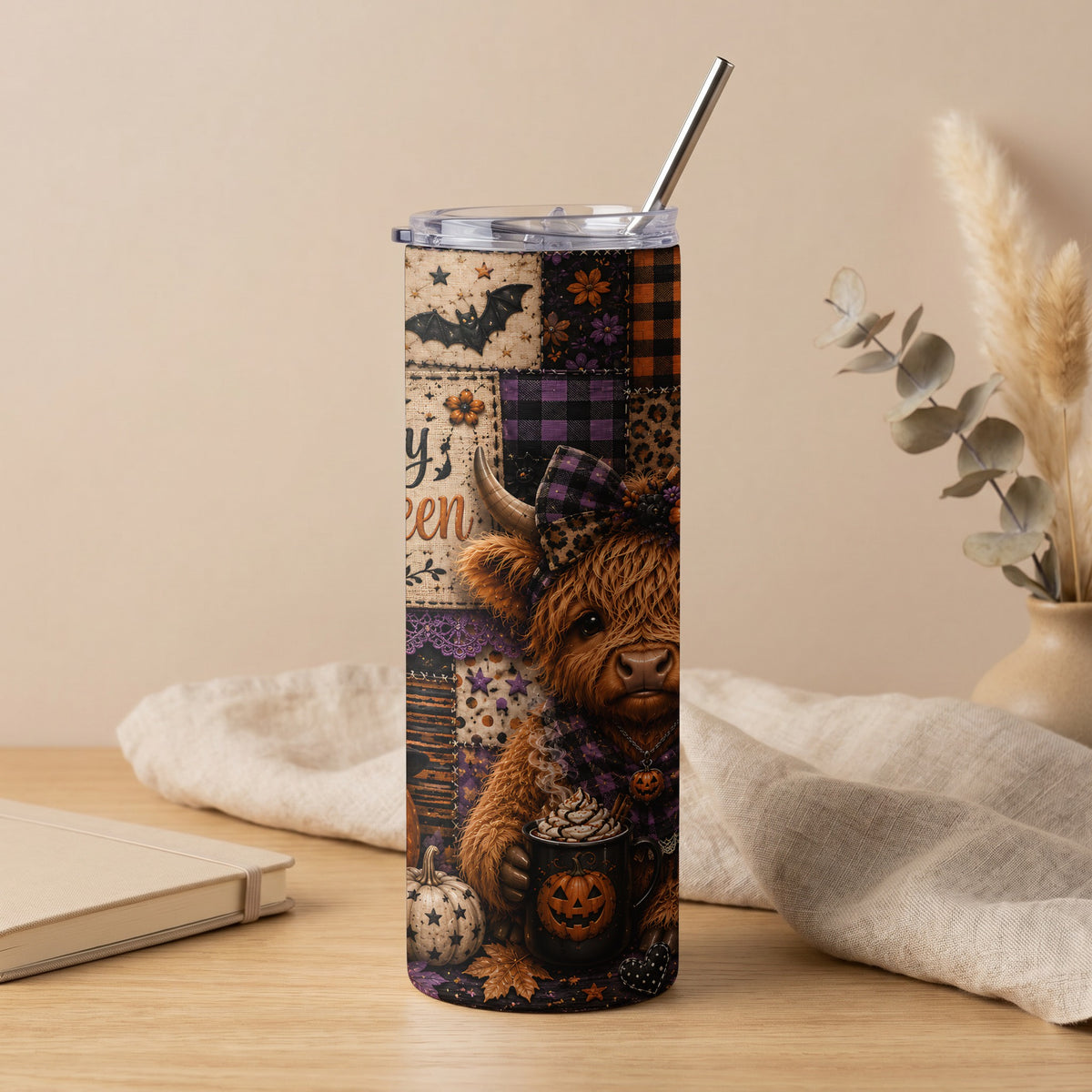 Highland cow in patchwork Halloween tumbler with pumpkin spice latte and fall leaves.