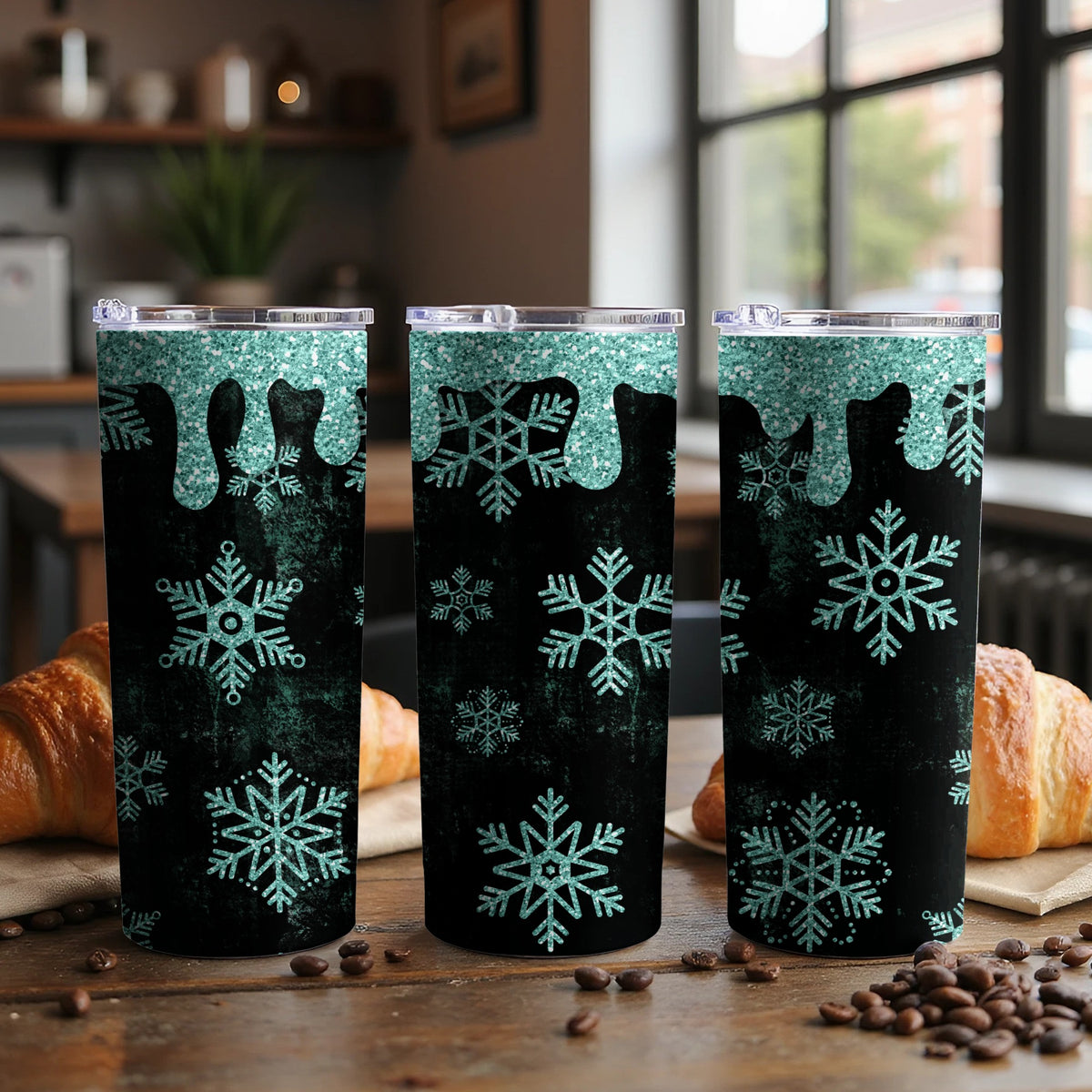 Three tumblers with teal glitter drips and snowflake patterns on a black background.