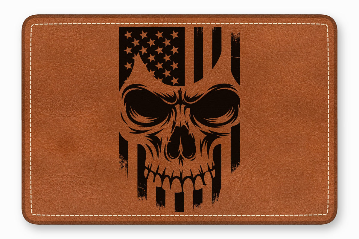 Brown rectangular leather patch with rounded corners, featuring a black laser-engraved American flag skull design and white stitching.