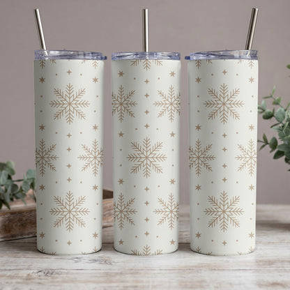 Three white tumblers with gold snowflakes and stars pattern, each with a metal straw.