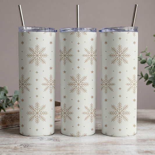 Three white tumblers with gold snowflakes and stars pattern, each with a metal straw.