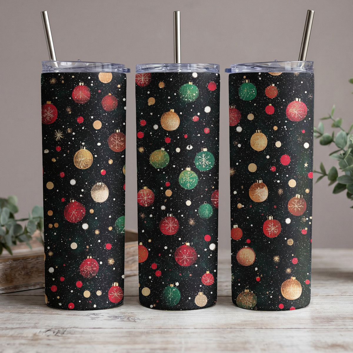 Three tumblers with a black background featuring a scattered pattern of Christmas ornaments and dots.