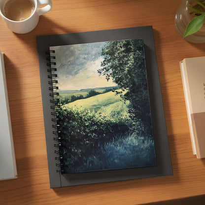 Spiral notebook with a landscape painting of rolling green hills and trees.