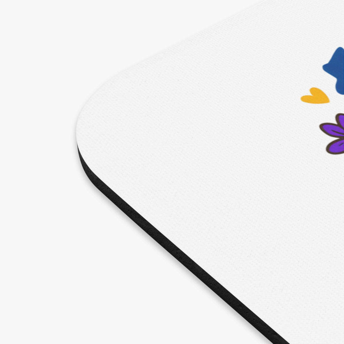 White mousepad with a blue shape, yellow heart, and purple flower design.