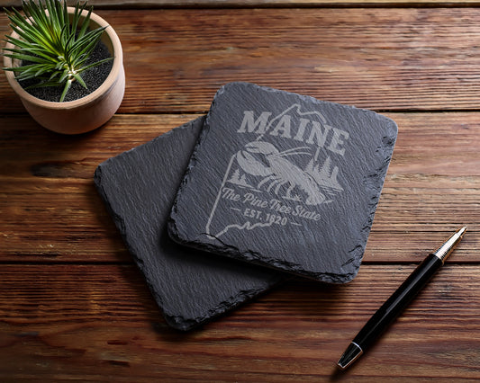 Two slate coasters with Maine lobster and "The Pine Tree State EST. 1820" engraving.
