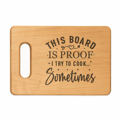 Wooden cutting board with text "This board is proof I try to cook... Sometimes".