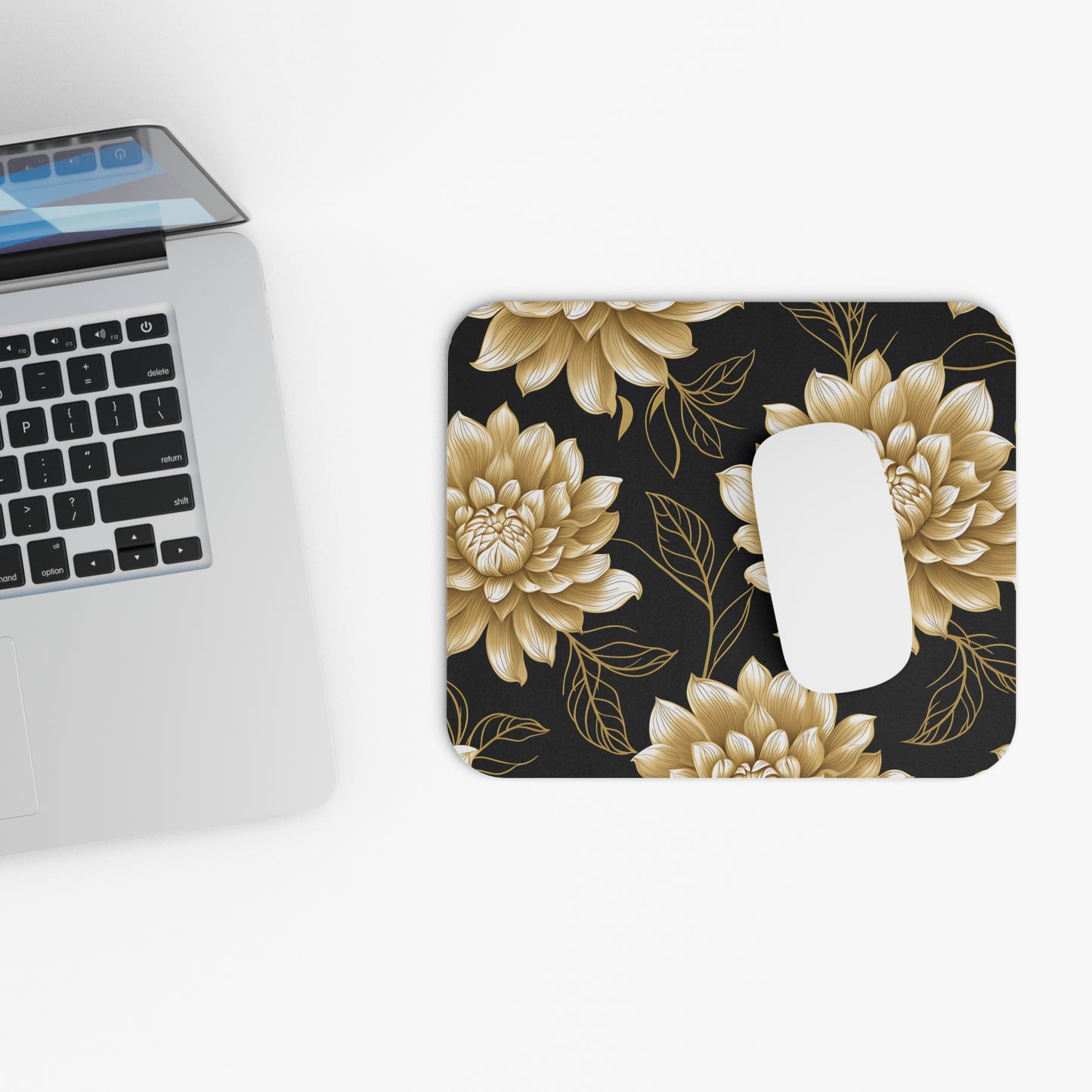 Mousepad with a gold floral pattern and a white computer mouse.