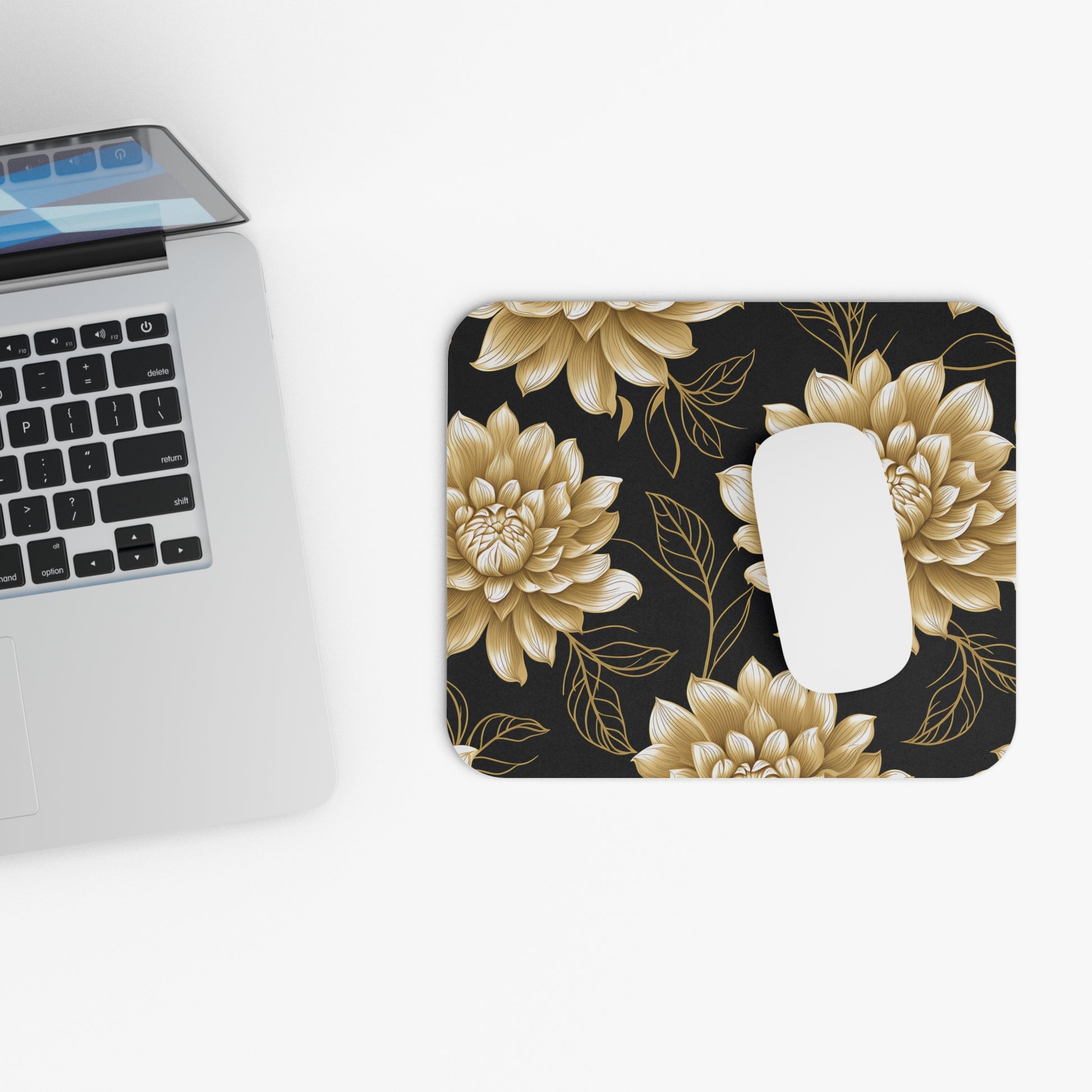 Mousepad with a gold floral pattern and a white computer mouse.