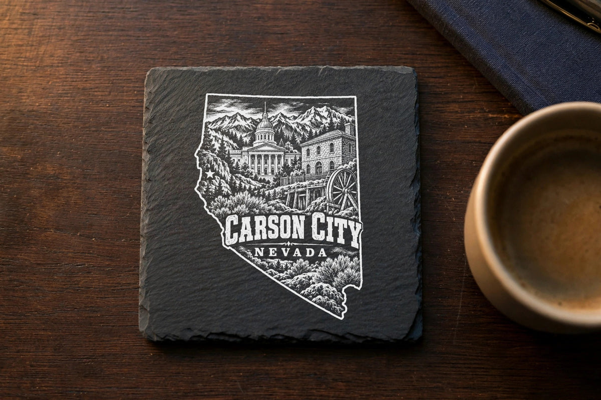 A square black slate coaster engraved with a Nevada state outline, Carson City landmarks, and text.