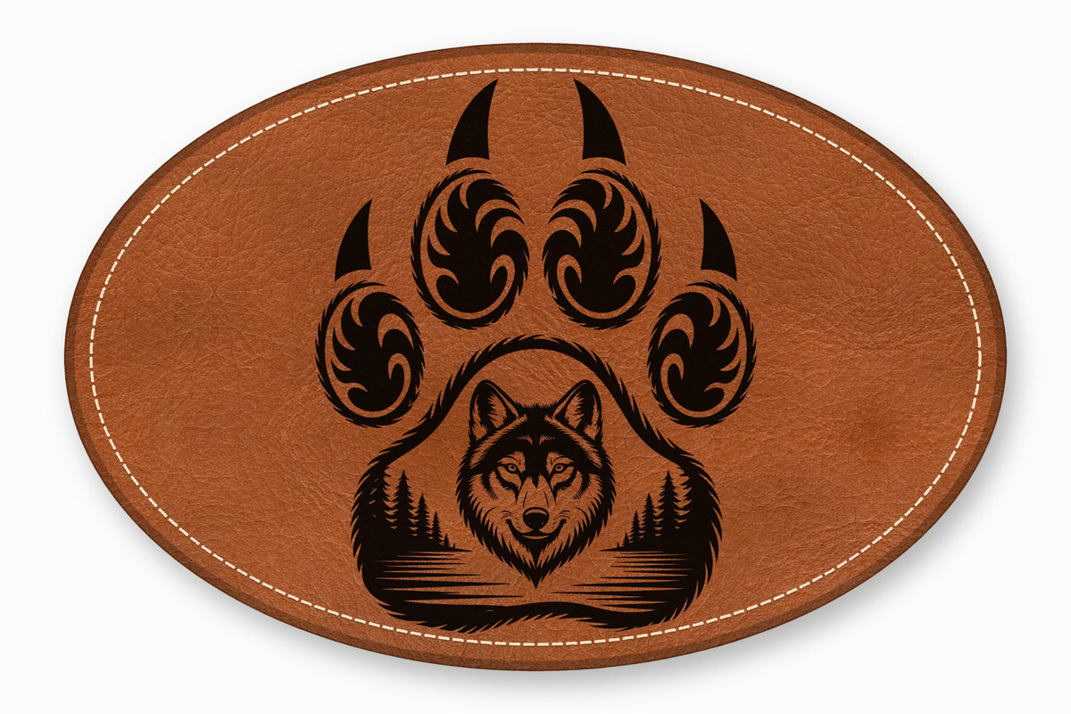 An oval brown leather patch with white stitched edges features a black bear paw graphic framing a wolf head and forest landscape.