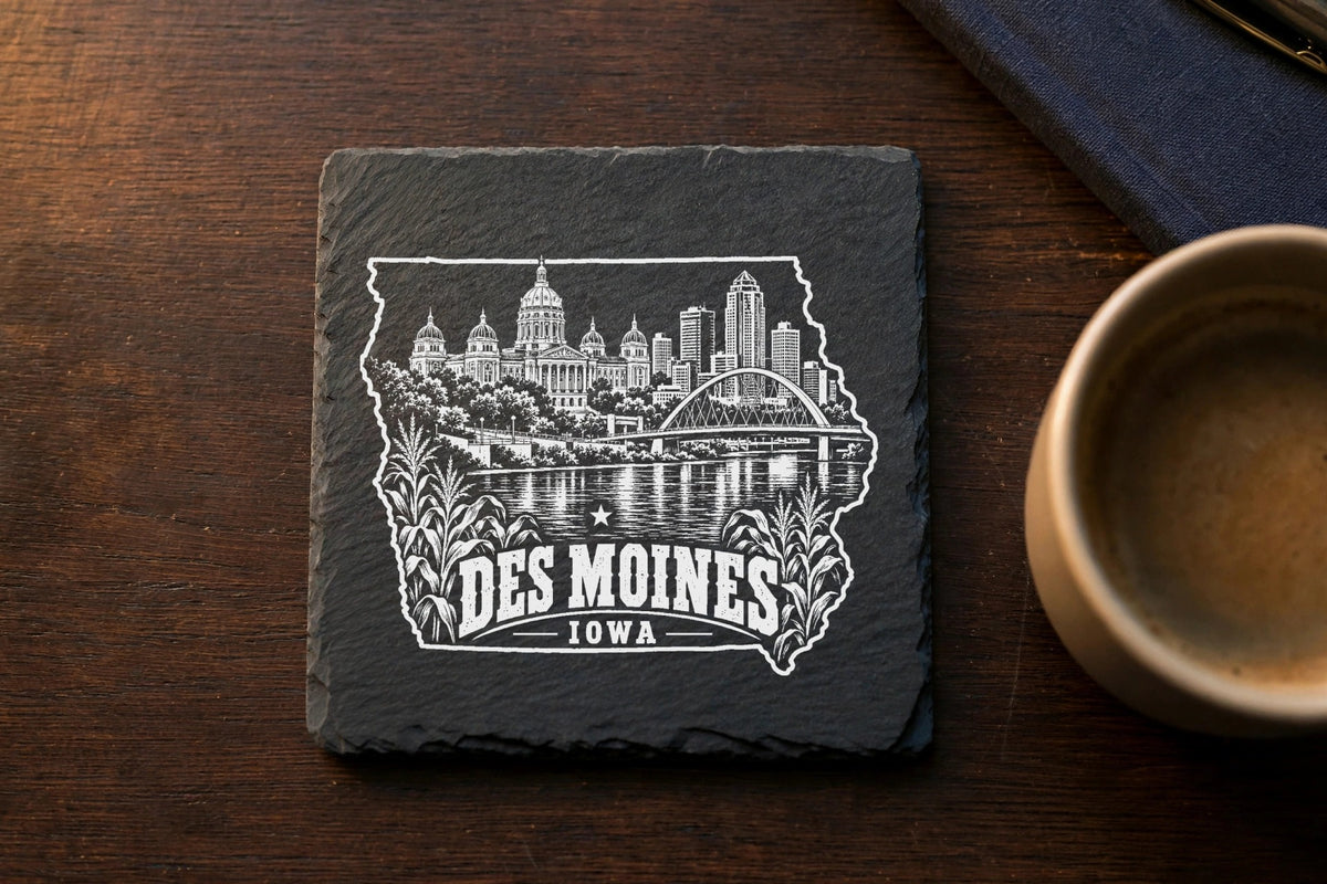 Square slate coaster featuring a white engraved Des Moines skyline inside an outline of Iowa.