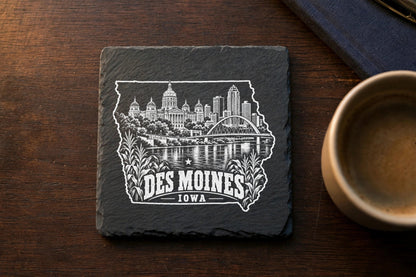 Square slate coaster featuring a white engraved Des Moines skyline inside an outline of Iowa.