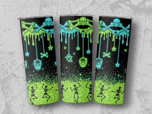 Three tumblers with a black background featuring a neon green and blue Halloween design with skulls and skeletons.