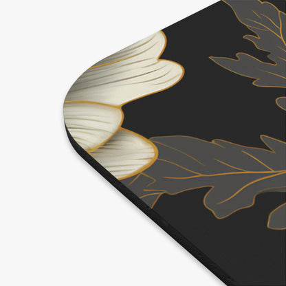 Close-up of a black mousepad with a white flower and grey leaf design.