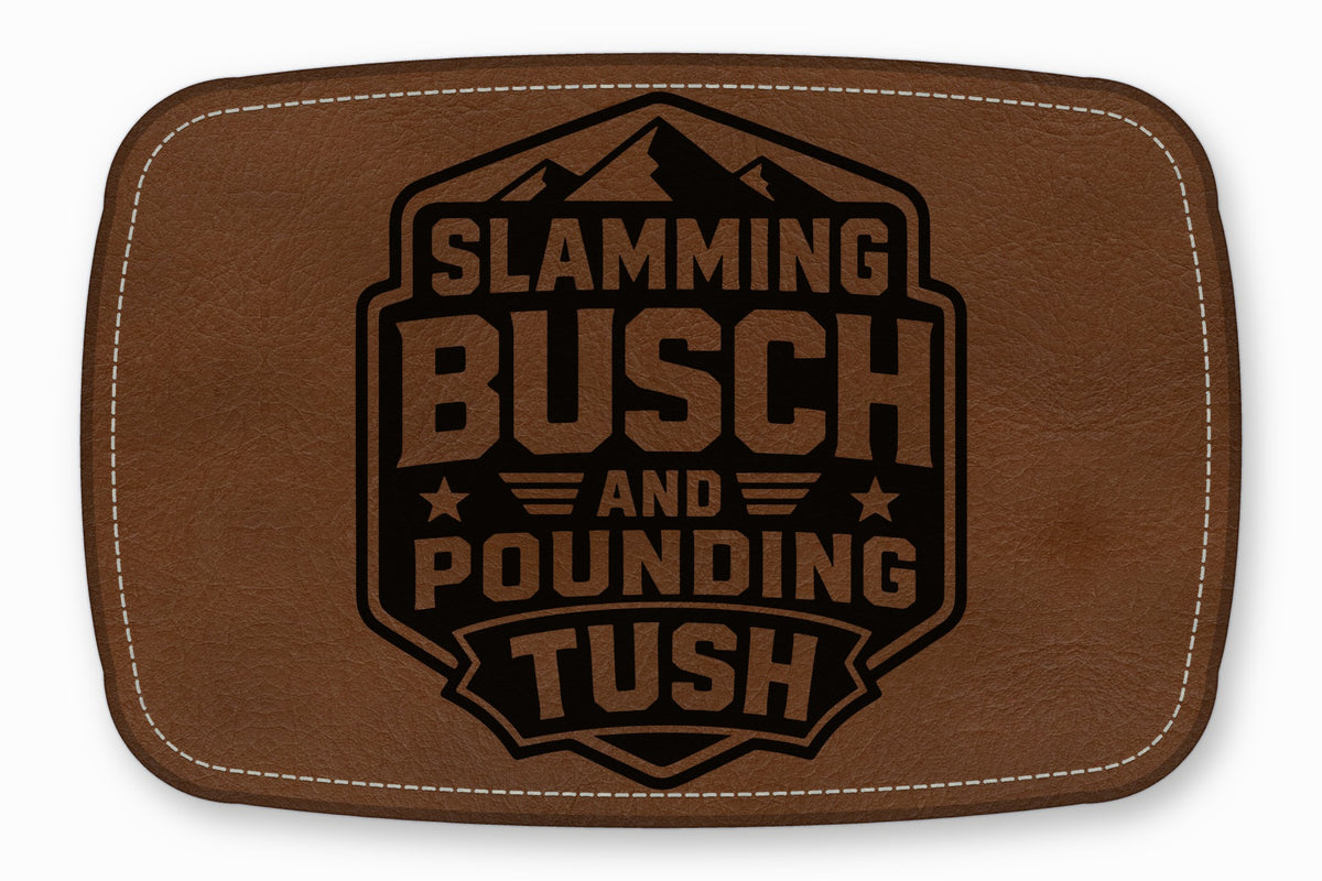 Brown rectangular faux leather patch with white stitching and a black engraved mountain logo and text reading Slamming Busch and Pounding Tush.
