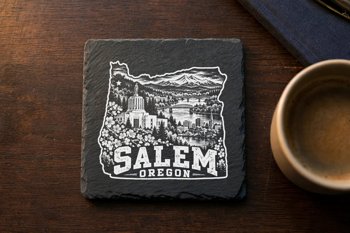 A square black slate coaster engraved with a detailed white graphic of Salem, Oregon.