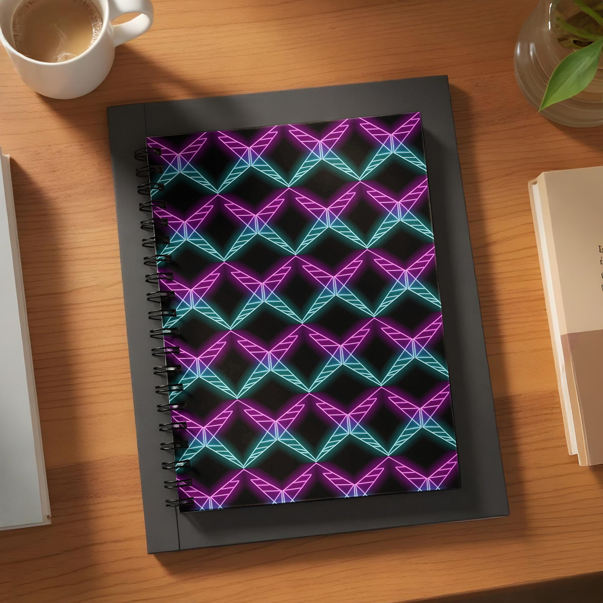 Spiral notebook with pink and teal geometric neon pattern on black background.