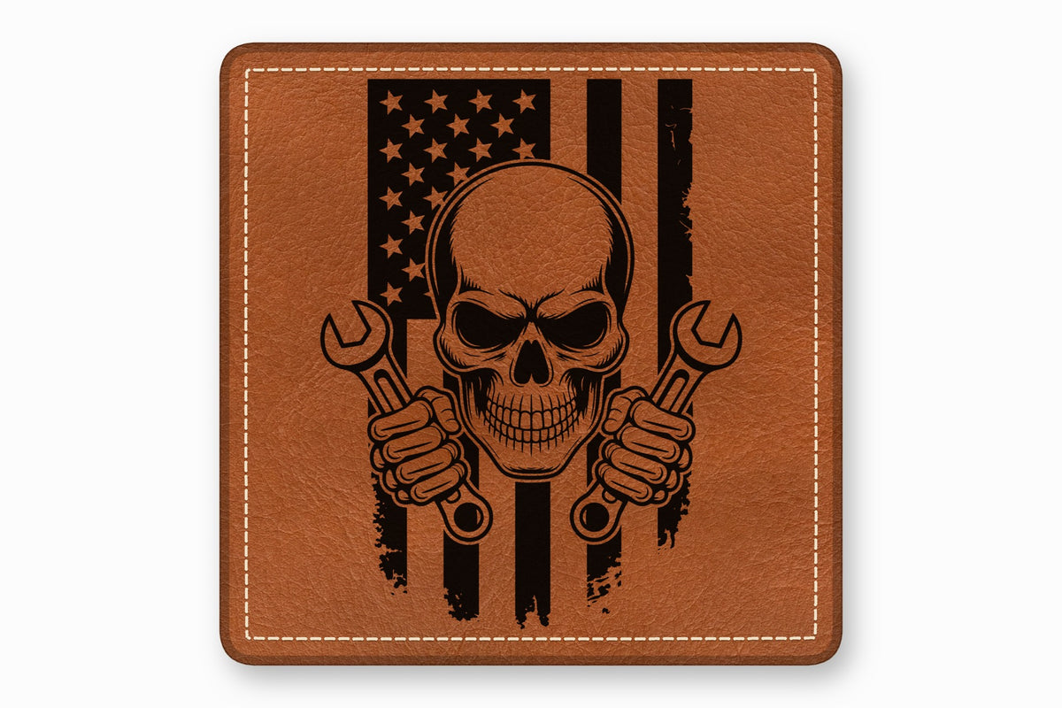 Square brown leather patch with white stitched border featuring a black skull holding wrenches over an American flag.