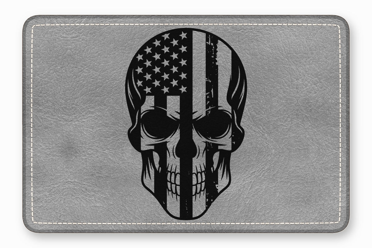 Rectangular gray leather patch featuring a black skull graphic with a distressed American flag pattern.