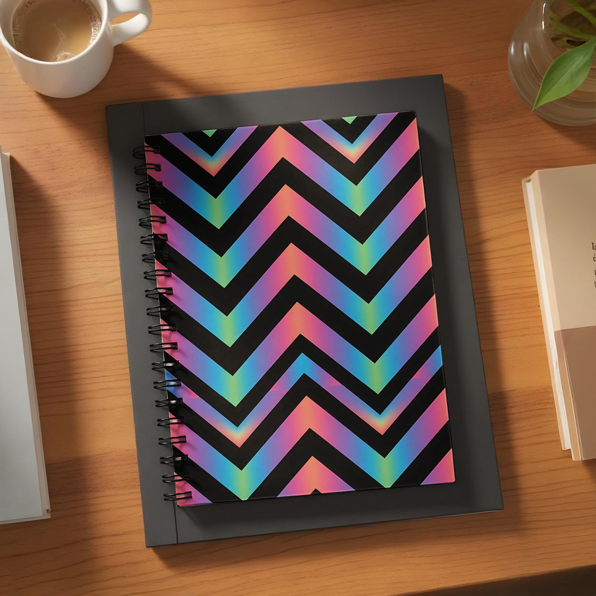 Spiral notebook with a black chevron pattern featuring a rainbow gradient.