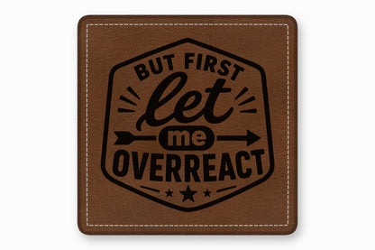 Square brown leather patch with white stitched border and black engraved text reading But First Let Me Overreact.