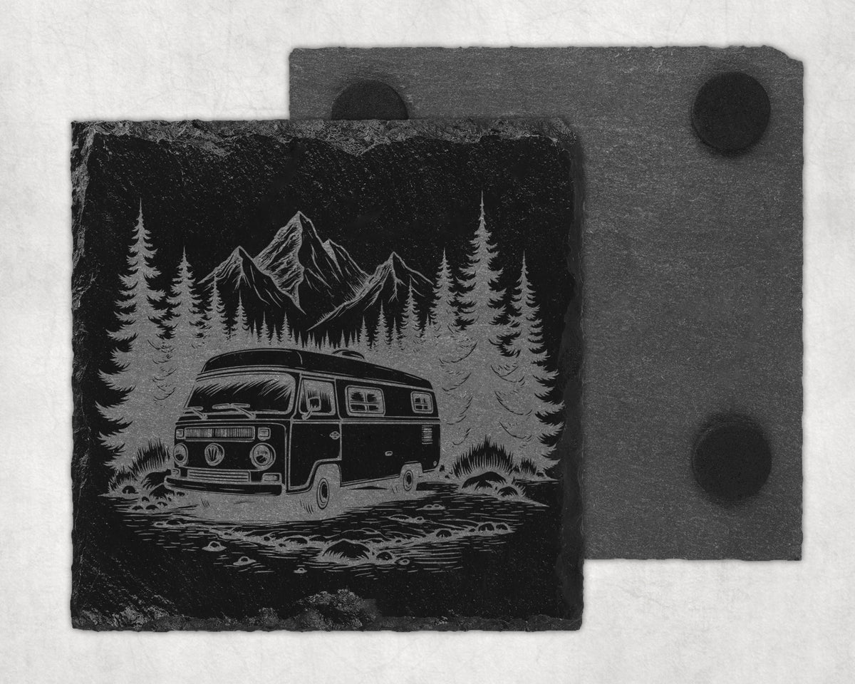 Slate coaster with etched design of a camper van parked in a forest with mountains.