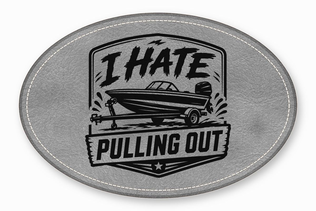 An oval gray leather patch with white stitching featuring a boat graphic and the text I HATE PULLING OUT.