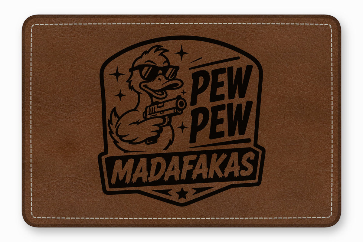 Brown rectangular leather patch stamped with a duck wearing sunglasses and holding a gun, accompanied by the text PEW PEW MADAFAKAS.